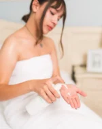 mujer joven usa la crema corporal